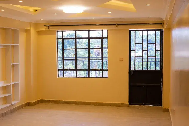 Bright yellow living room with large windows and built-in shelving