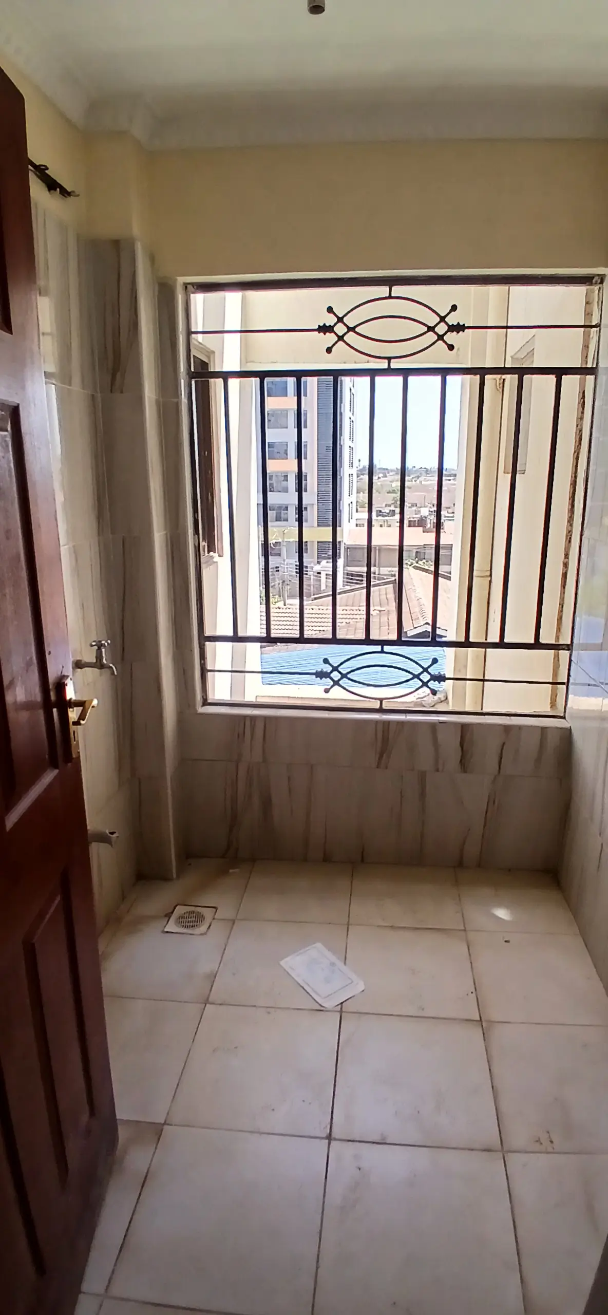 Modest bedroom with barred window and tiled floor