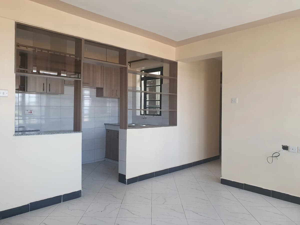 Open-plan kitchen with white tiles and dark cabinetry