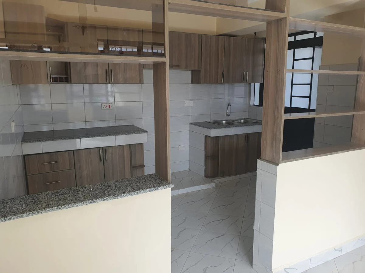 Open-plan kitchen with granite counters, brown cabinetry, tiled backsplash