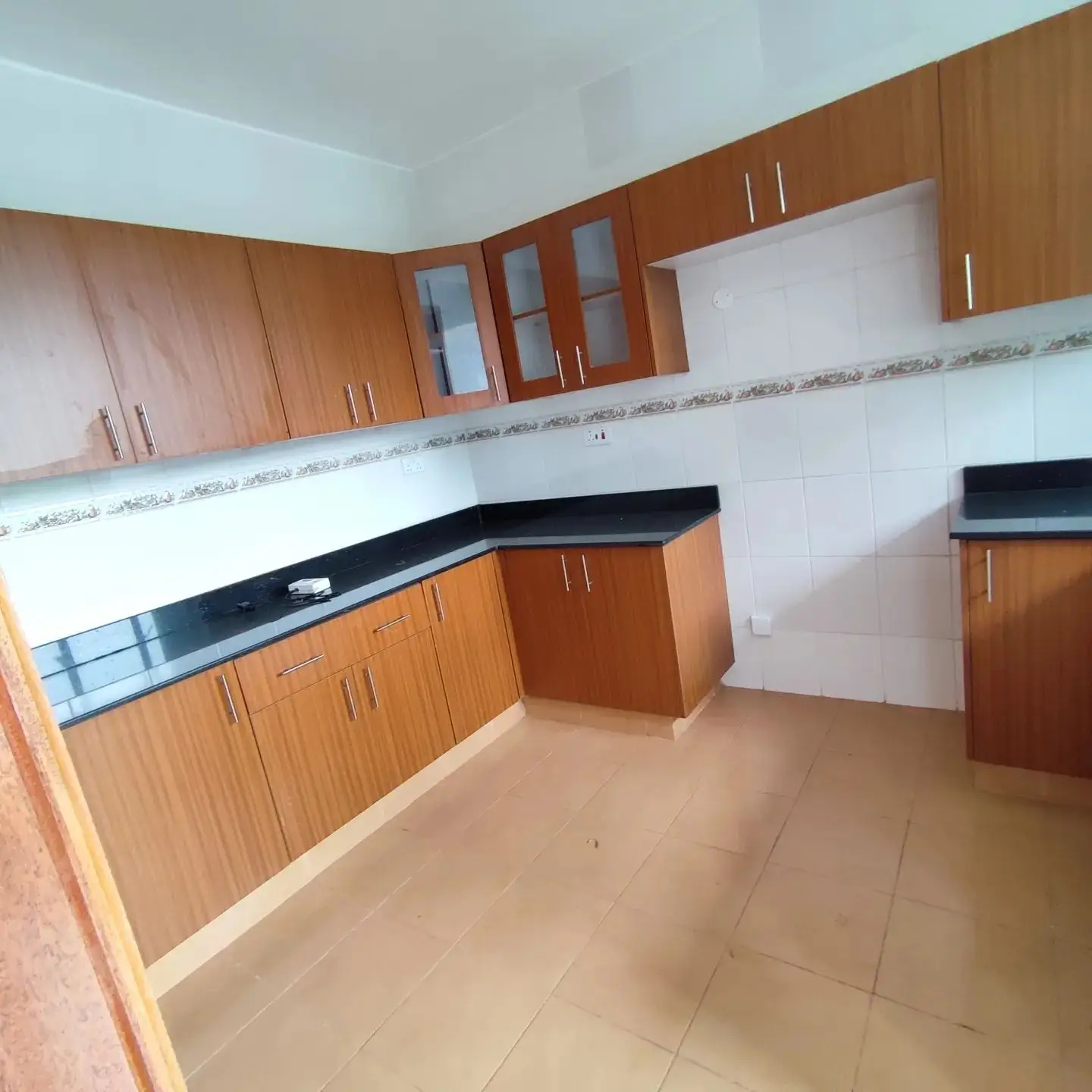 Spacious kitchen with wooden cabinets and black countertops