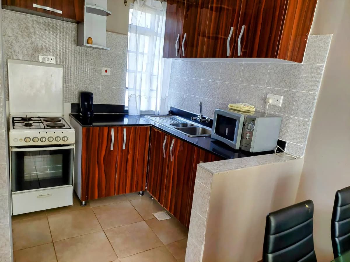 Modern kitchen with wooden cabinets, granite counters, stove and sink