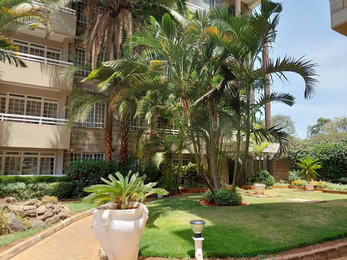 Lush compound grounds with mature palms and manicured lawn