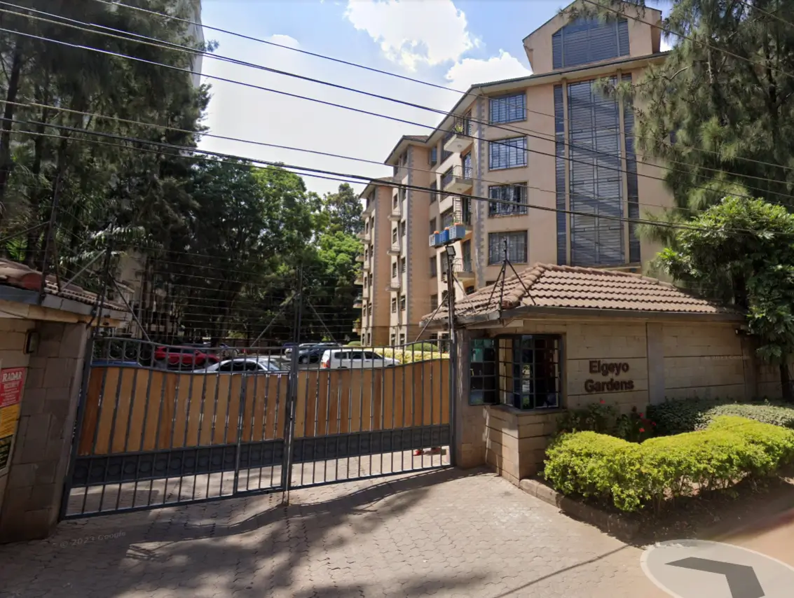 Apartment building entrance with gated compound and landscaping