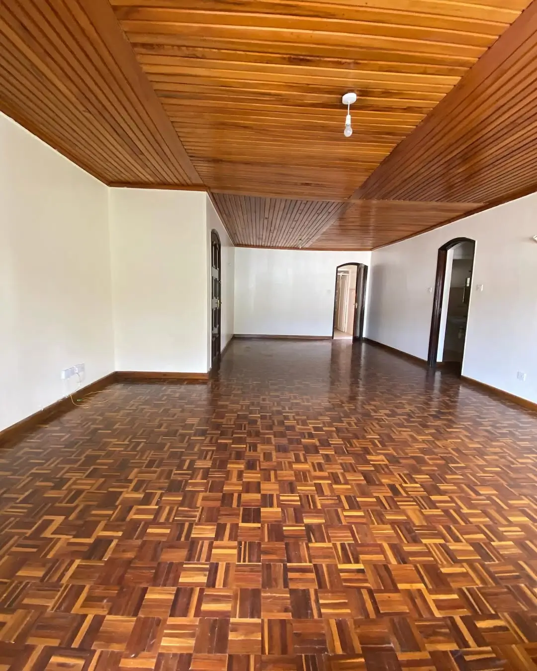 Spacious living room with wooden ceiling and parquet flooring