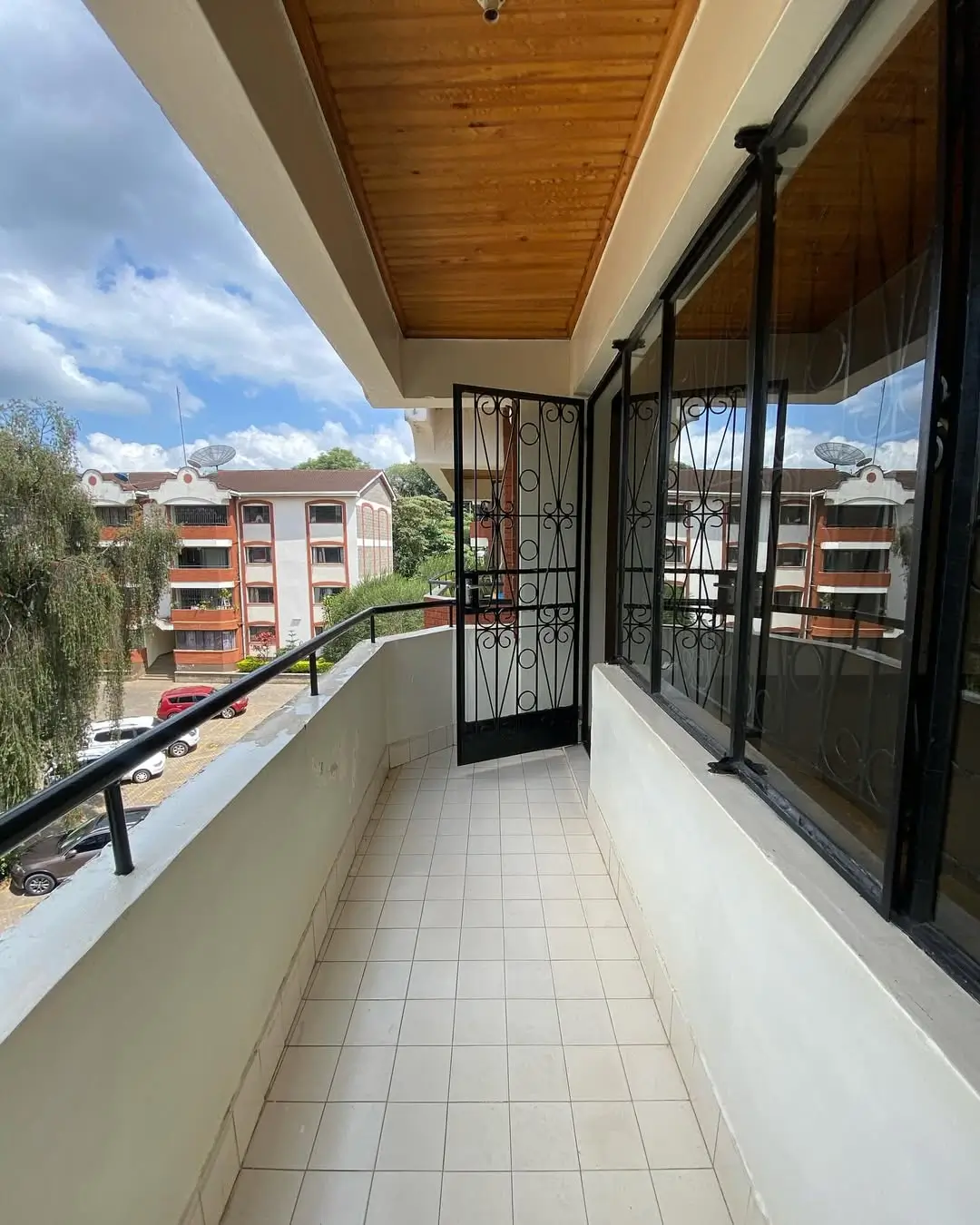 Spacious covered balcony with city views and neighboring apartments