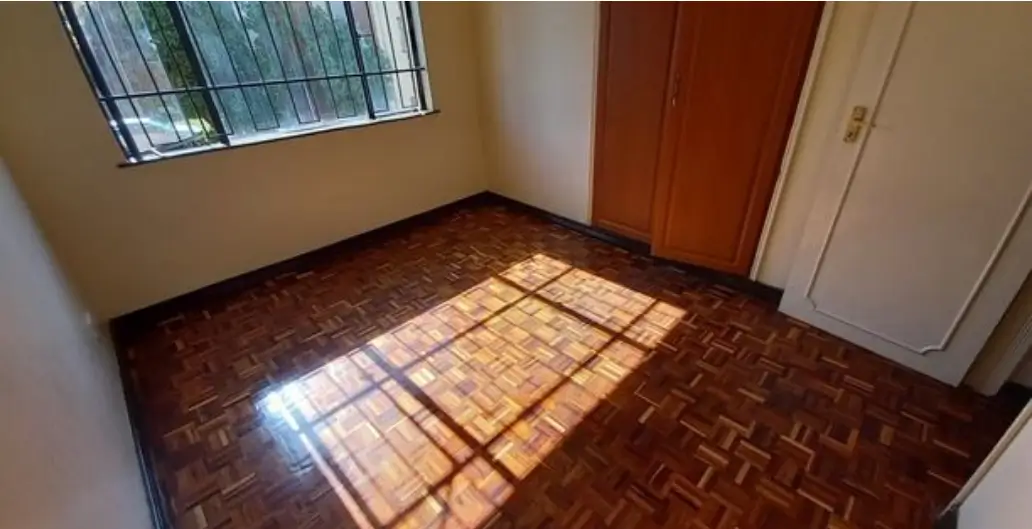 Bright bedroom with parquet flooring and natural light