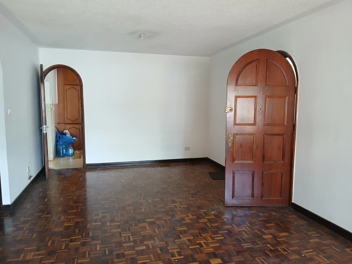 Spacious living room with parquet flooring and wooden doors