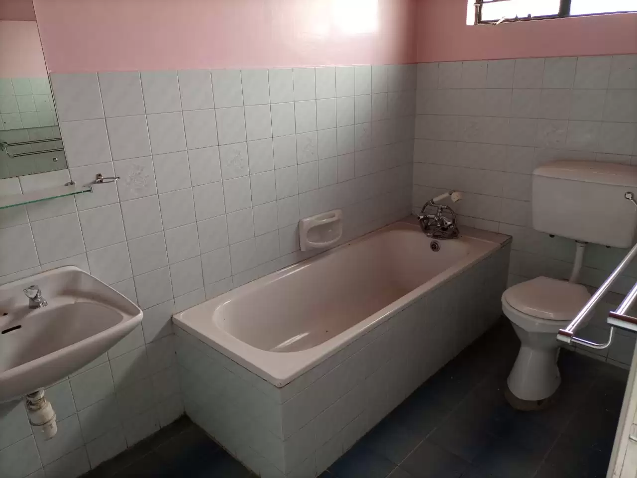 Basic bathroom with bathtub, sink, toilet, white tile walls