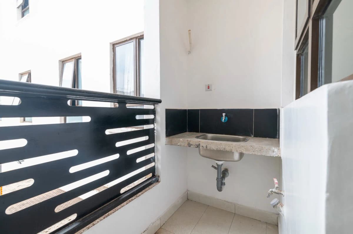Basic bathroom with wall-mounted sink and black tile backsplash
