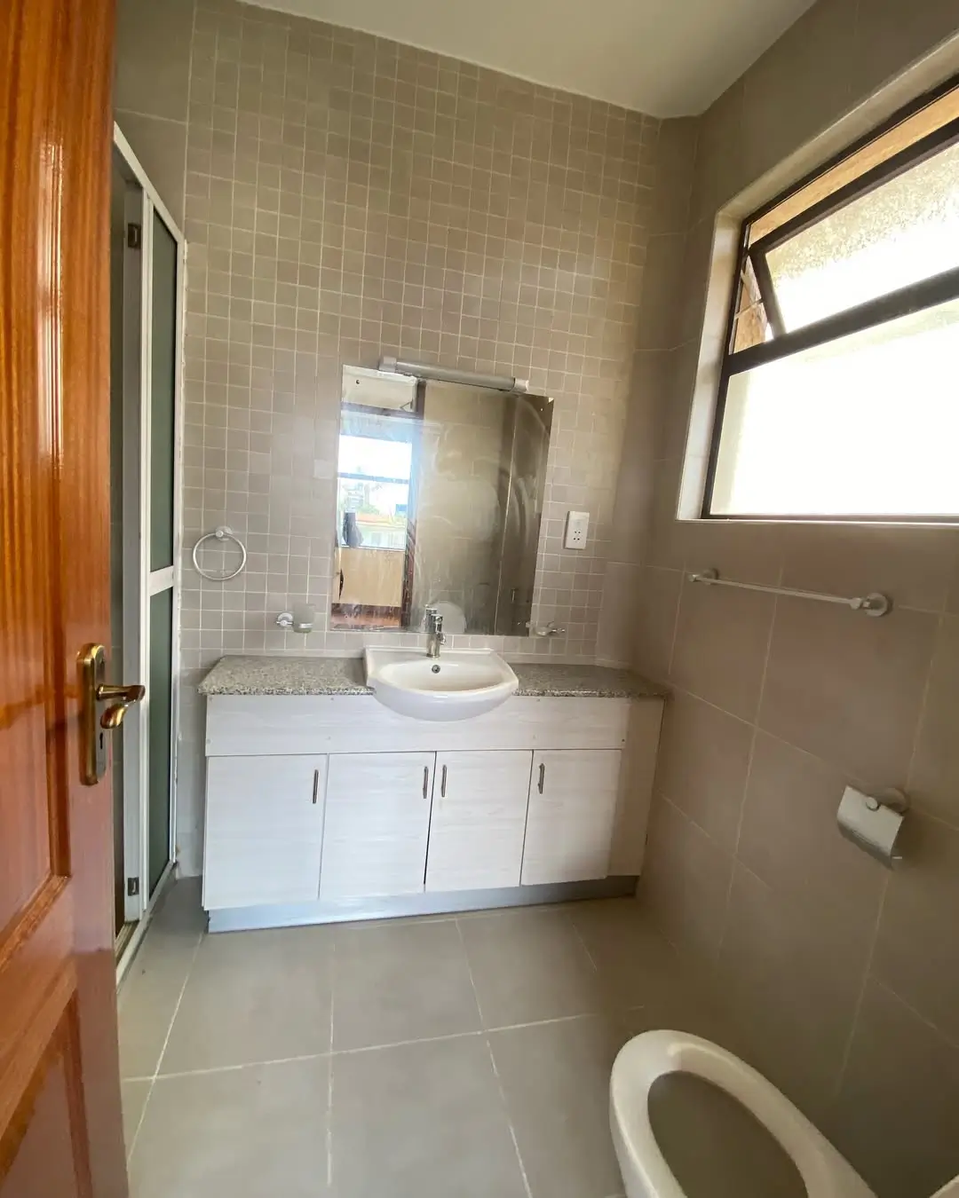 Modern bathroom with white vanity, mirror, and tiled walls