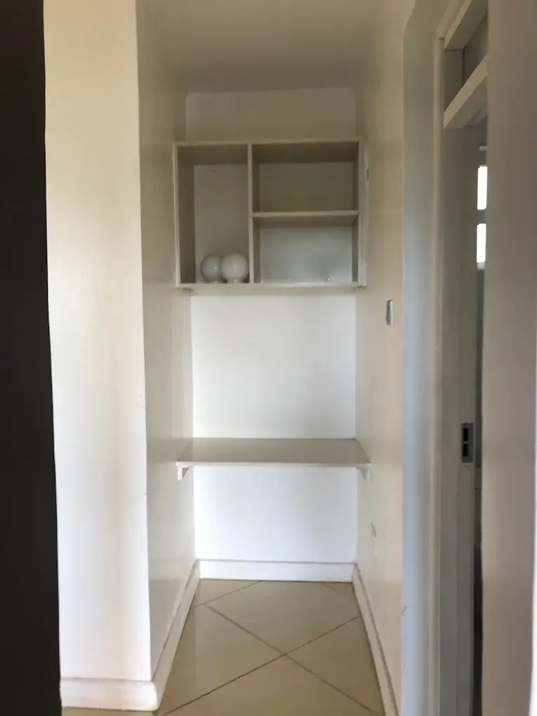 Compact pantry with shelving and tiled flooring
