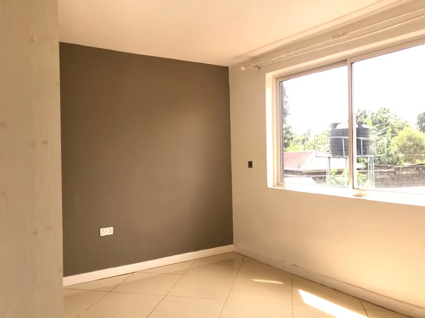 Unfurnished bedroom with accent wall and large window