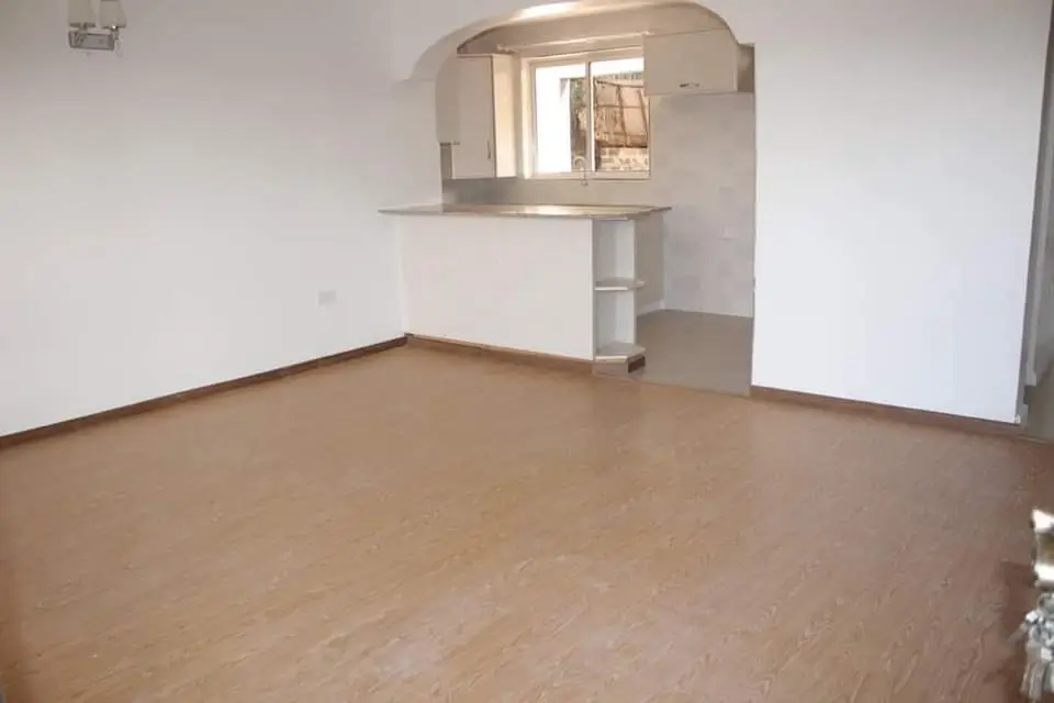 Spacious living room with wooden flooring and built-in shelving