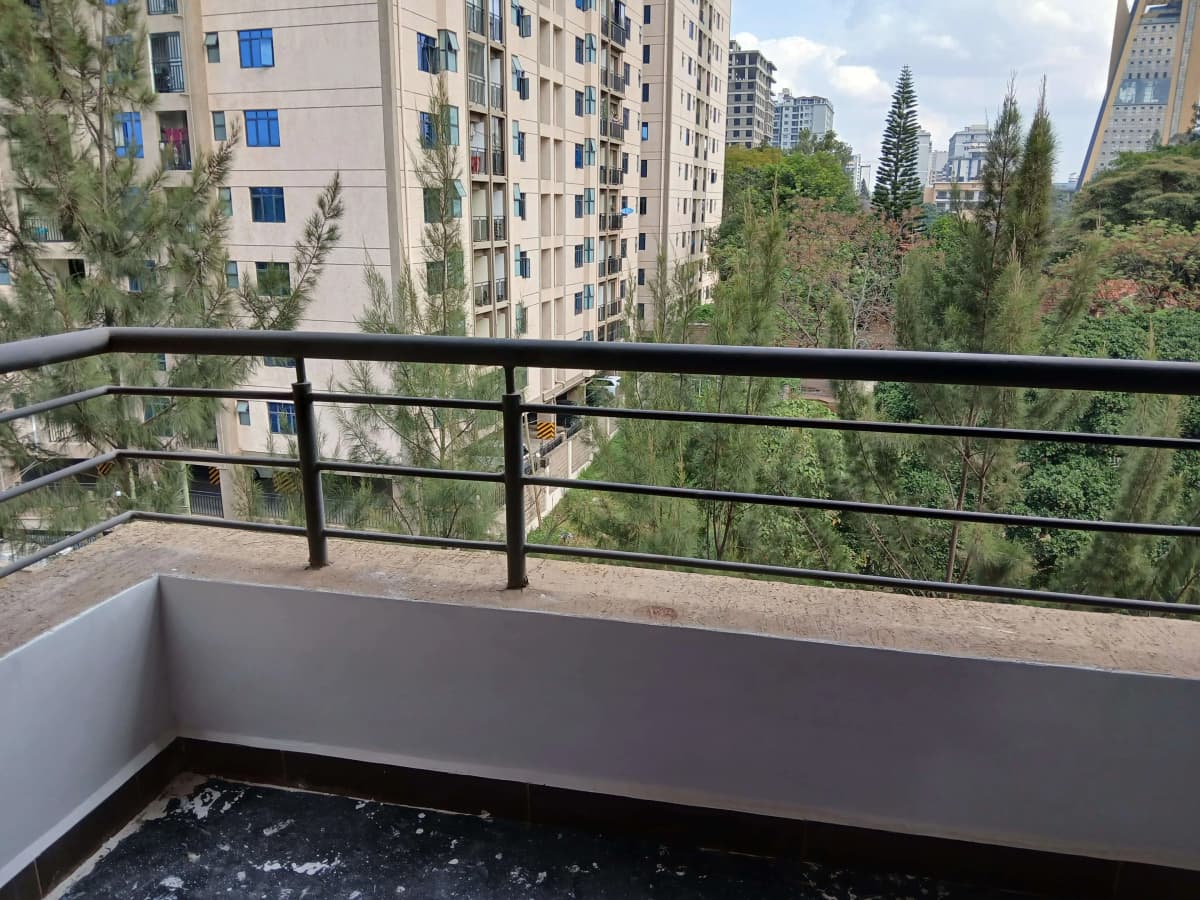 Elevated balcony with black railing overlooking urban compound