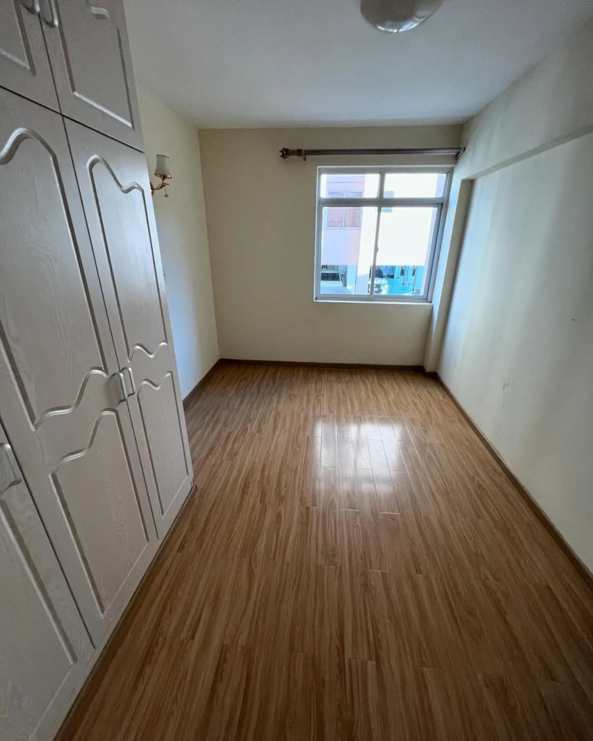 Spacious bedroom with wooden flooring and built-in wardrobes