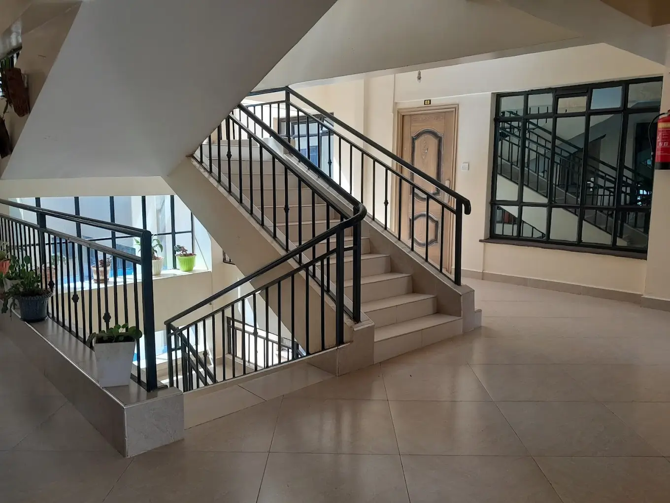 Modern lobby with central staircase and black metal railings