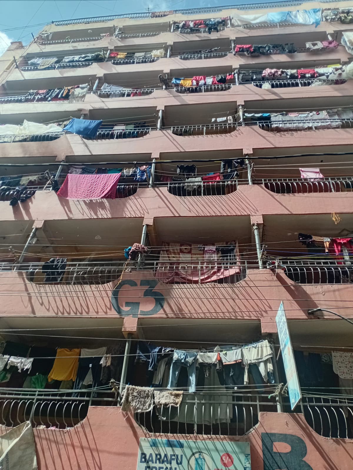 Multi-story residential building facade with multiple balconies and laundry