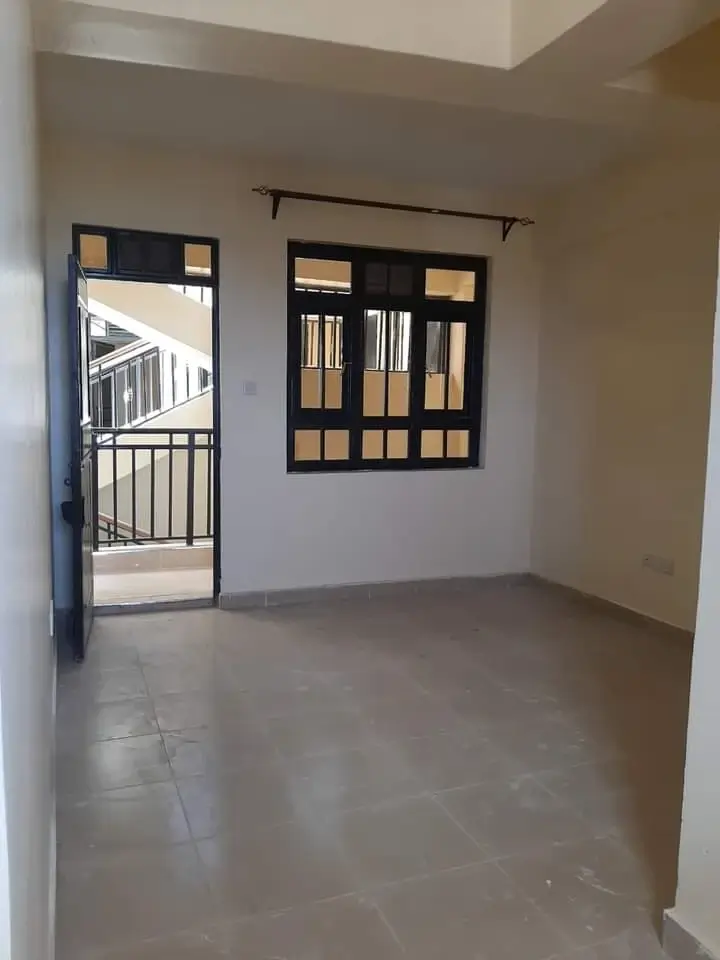 Unfurnished bedroom with polished concrete floor and balcony access