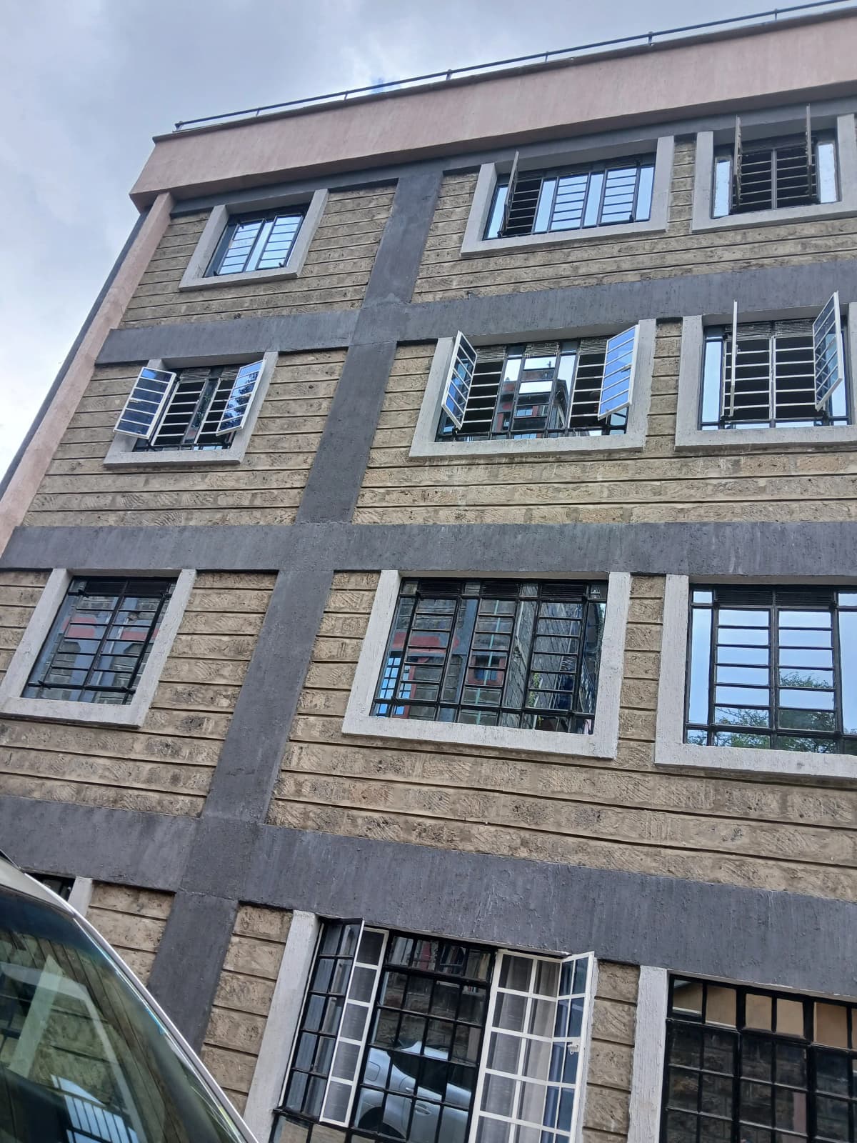 Four-story residential building facade with shuttered windows