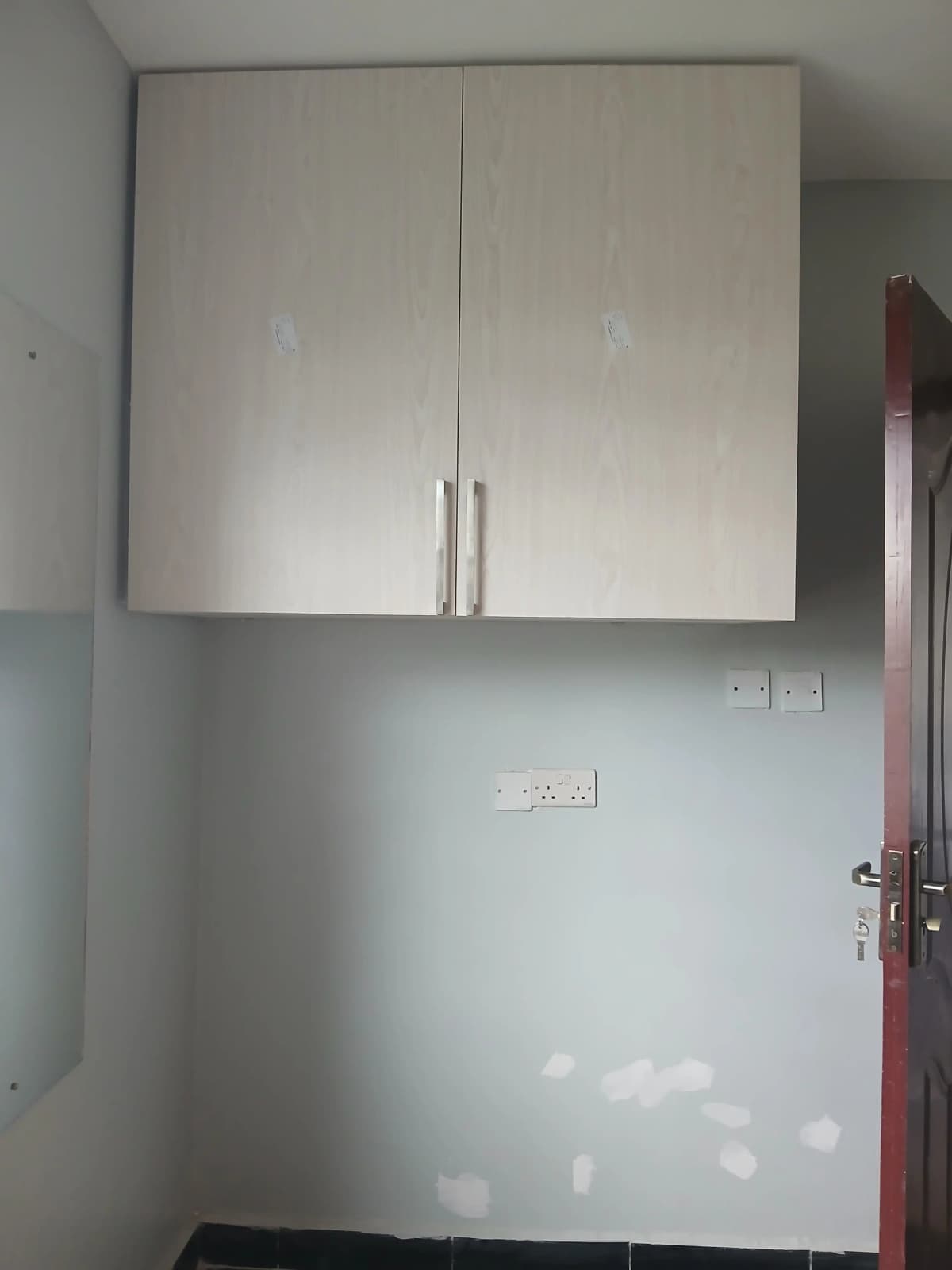 Minimalist kitchen with white cabinetry and stainless steel handles