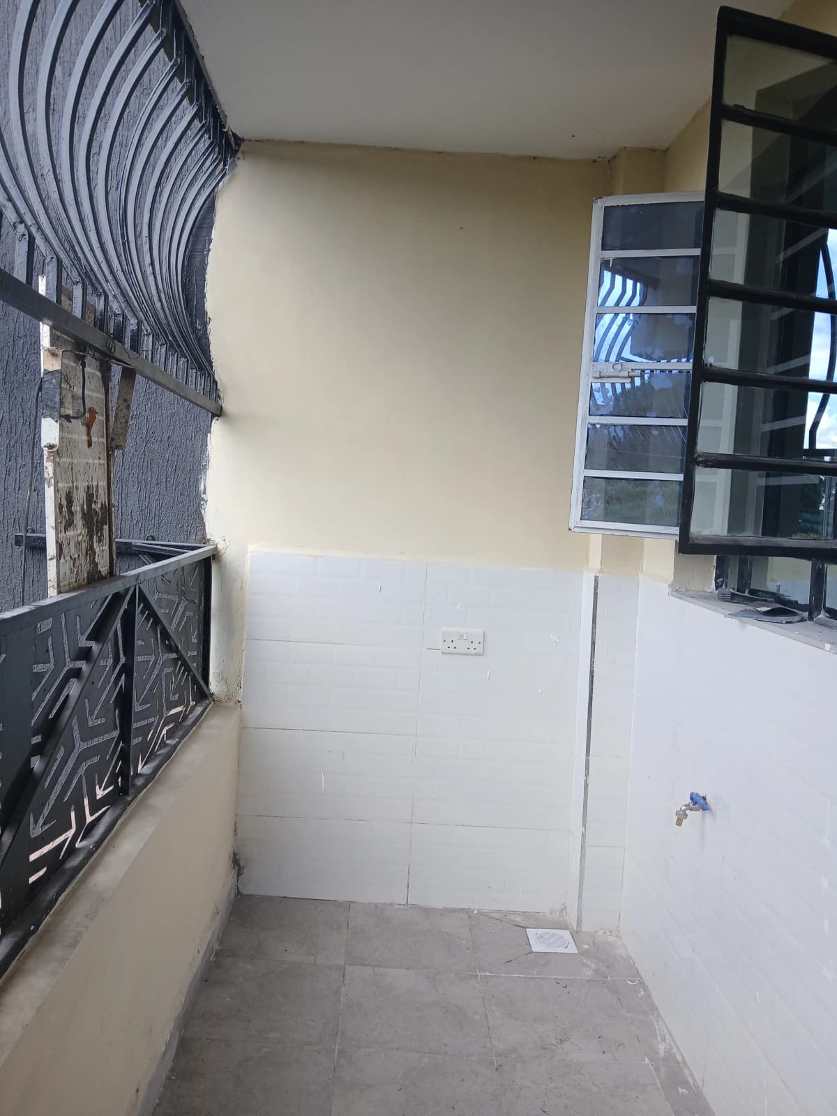 Narrow outdoor balcony with white walls and storage
