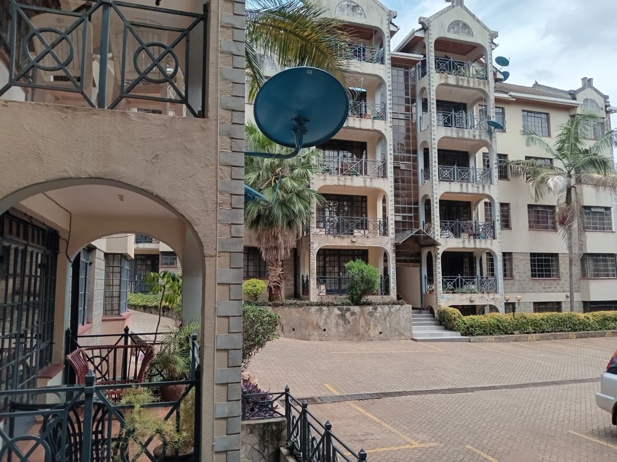 Multi-story residential complex with manicured courtyard and palm trees