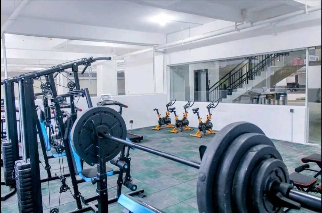 Modern gym with weights, cardio bikes, and training equipment