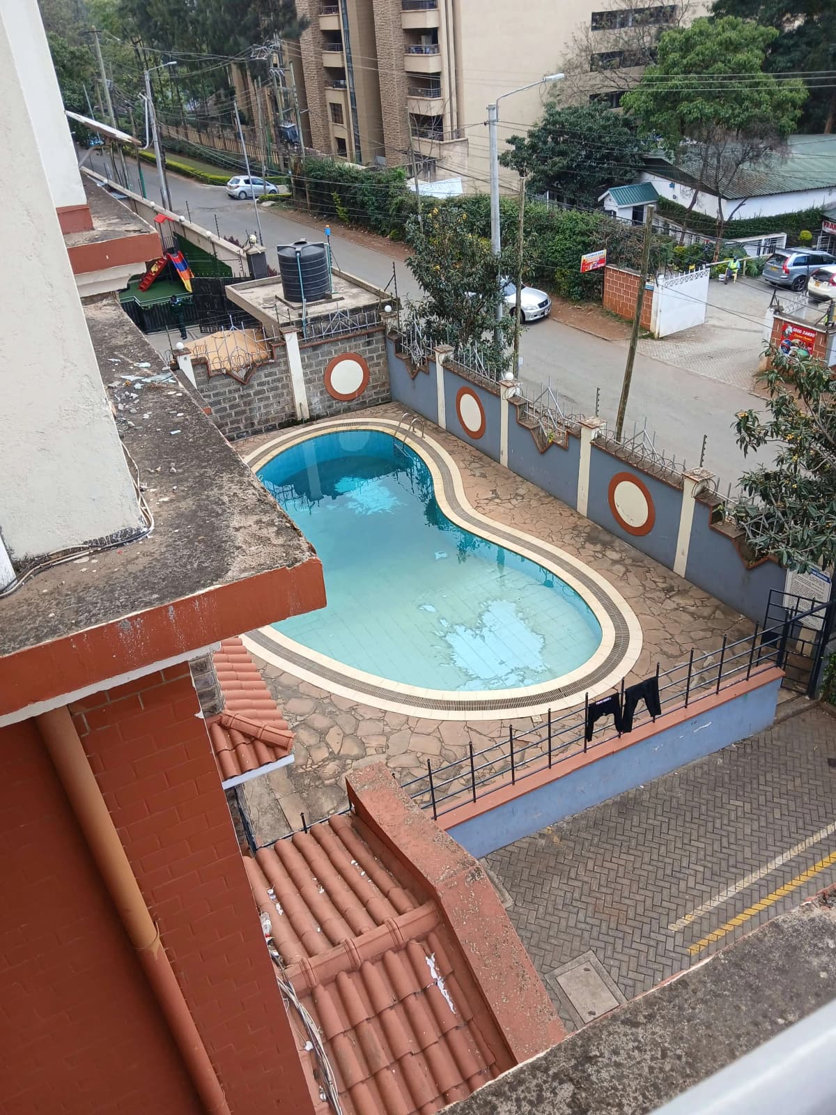Kidney-shaped swimming pool with blue water in compound