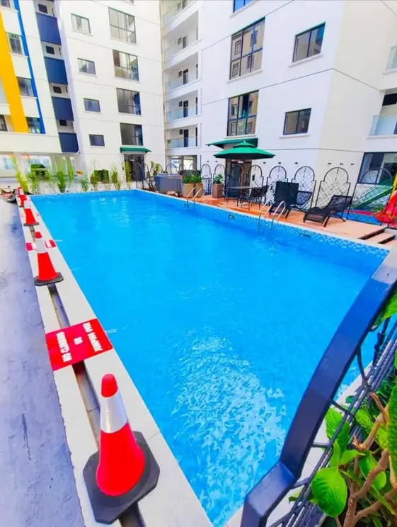 Bright blue rectangular swimming pool with lounge seating area