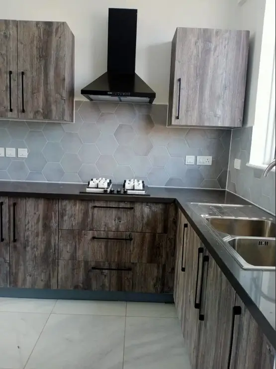 Modern kitchen with grey wood cabinetry and stainless steel sink