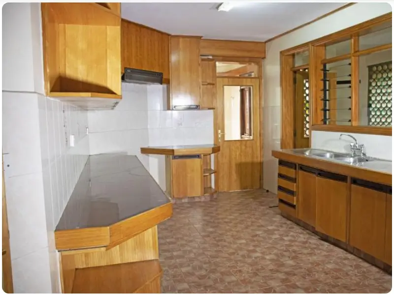 Spacious kitchen with wooden cabinetry and dark countertops
