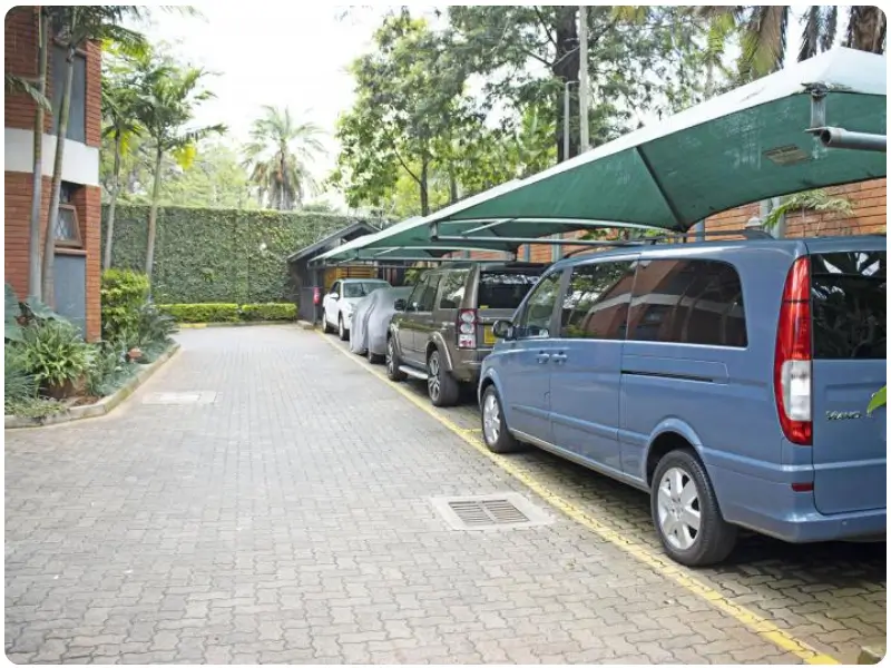 Covered carport with multiple vehicles parked in line