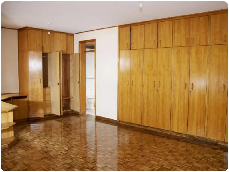 Spacious bedroom with extensive wooden built-in wardrobes