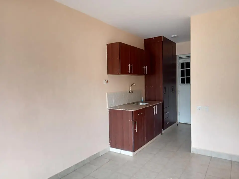 Compact kitchen with dark wood cabinets and stainless steel sink