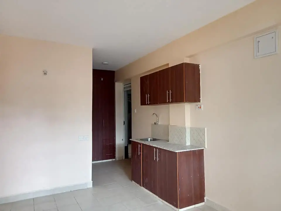Compact kitchen with dark wood cabinetry and stainless steel sink