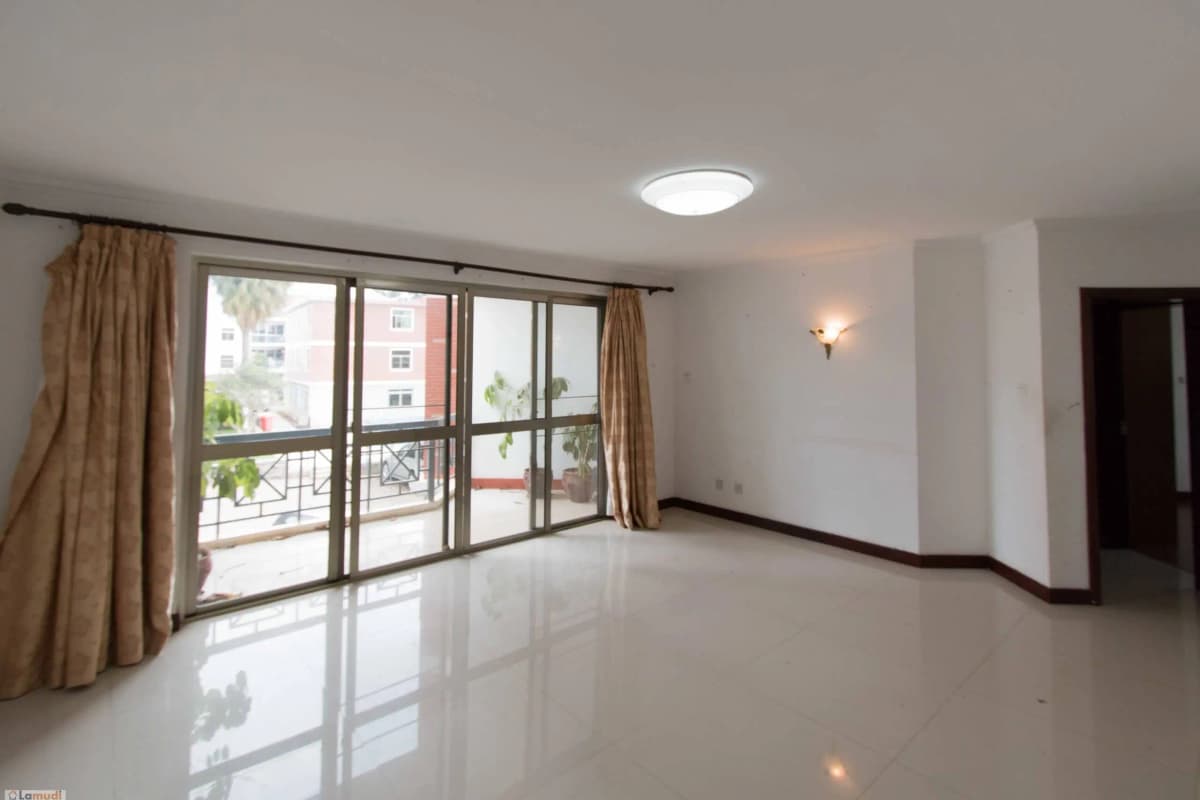 Spacious living room with floor-to-ceiling windows and balcony access