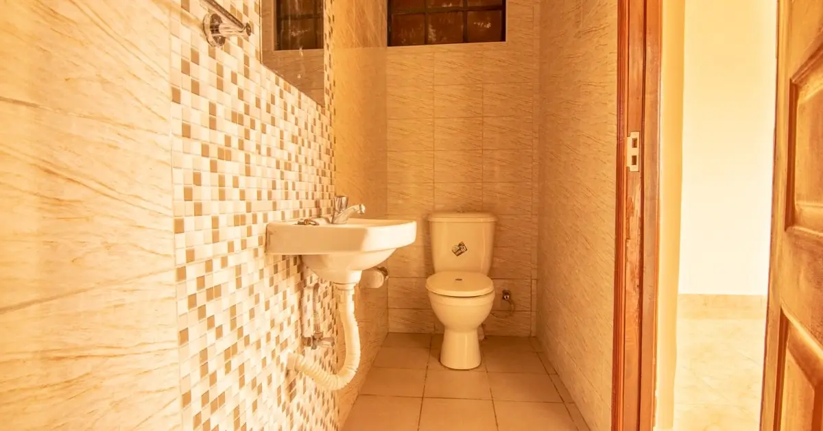 Compact bathroom with mosaic tile wall and ceramic fixtures