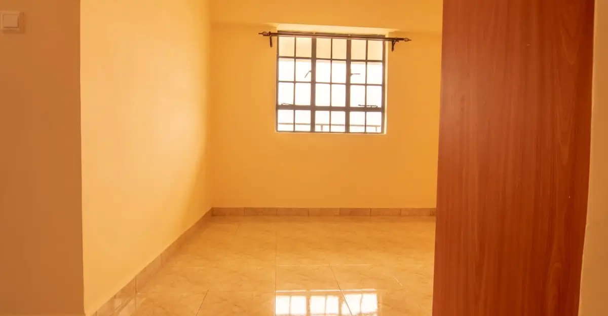 Empty bedroom with yellow walls and barred window