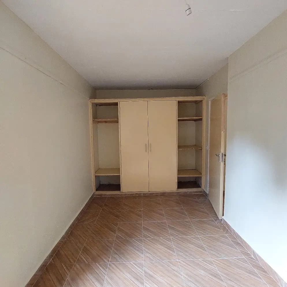 Spacious bedroom with built-in wooden wardrobe storage