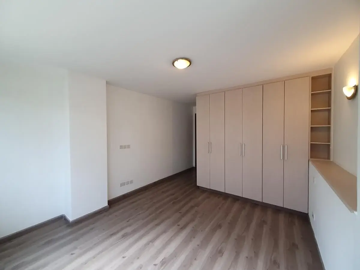 Spacious bedroom with built-in wardrobe and wooden flooring
