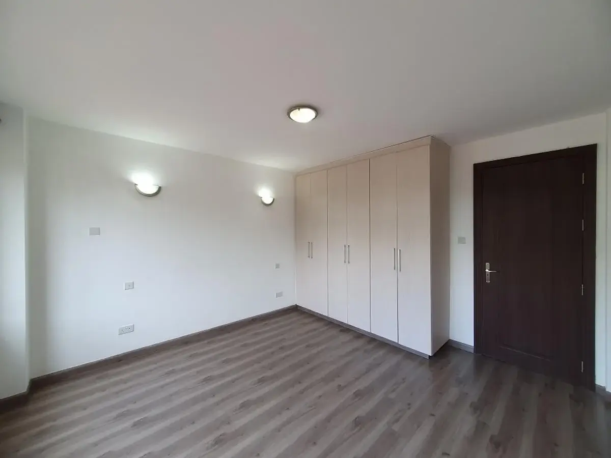 Spacious bedroom with built-in wardrobes and wooden flooring