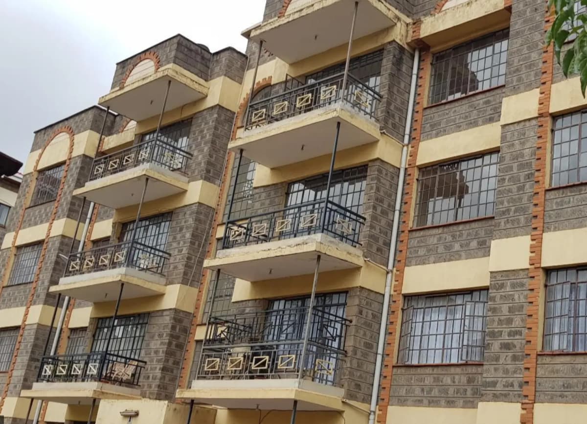 Multi-story residential building facade with balconies and stone cladding