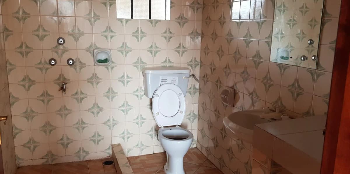 Compact bathroom with geometric tile walls and standard toilet