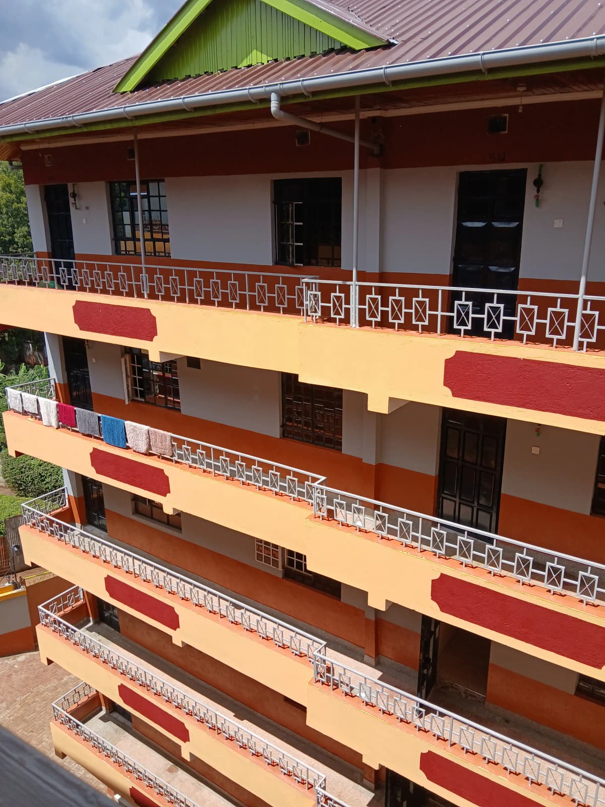 Multi-story residential building with yellow and red facade paint