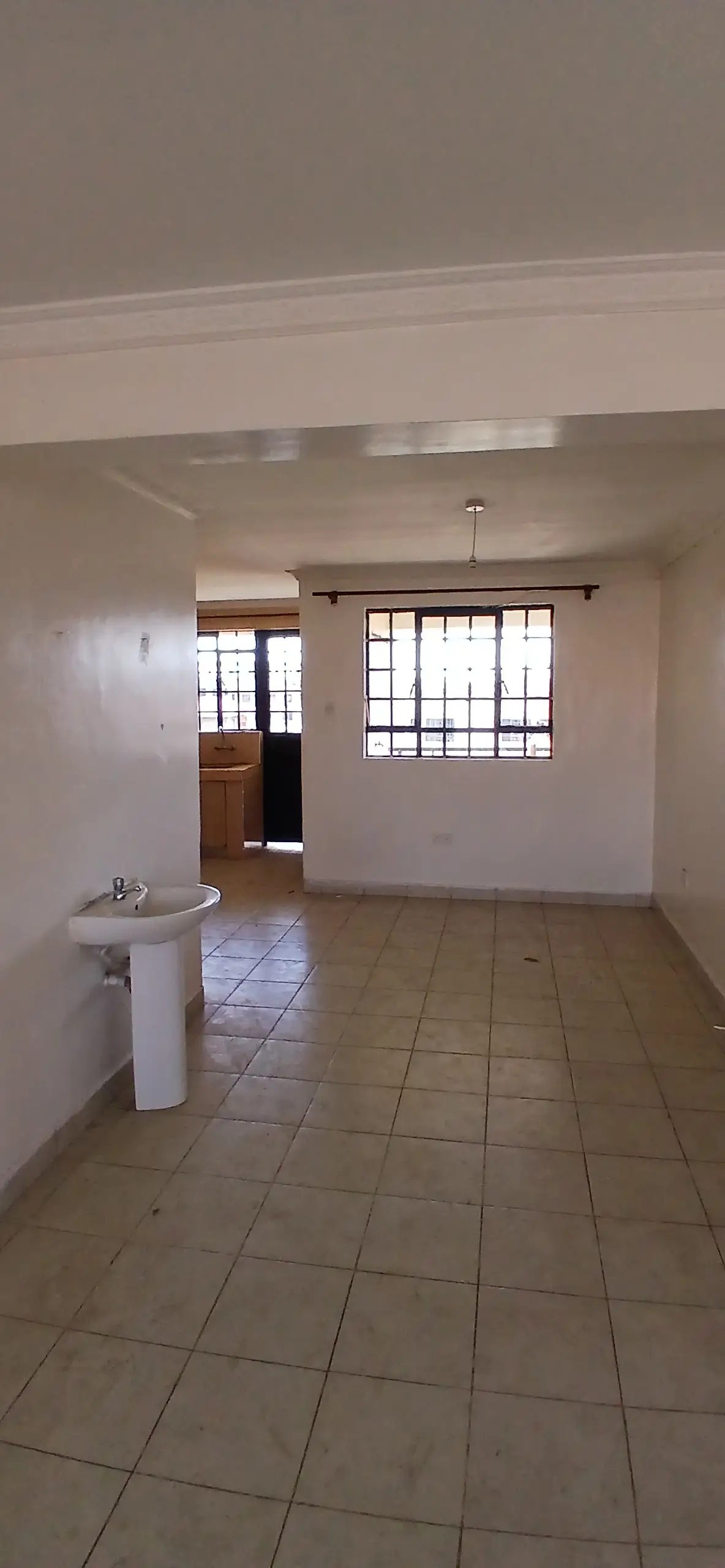 Open-plan living space with kitchenette and tiled flooring