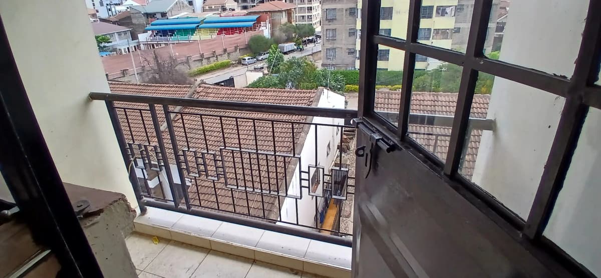 Balcony with railing overlooking residential compound and streets