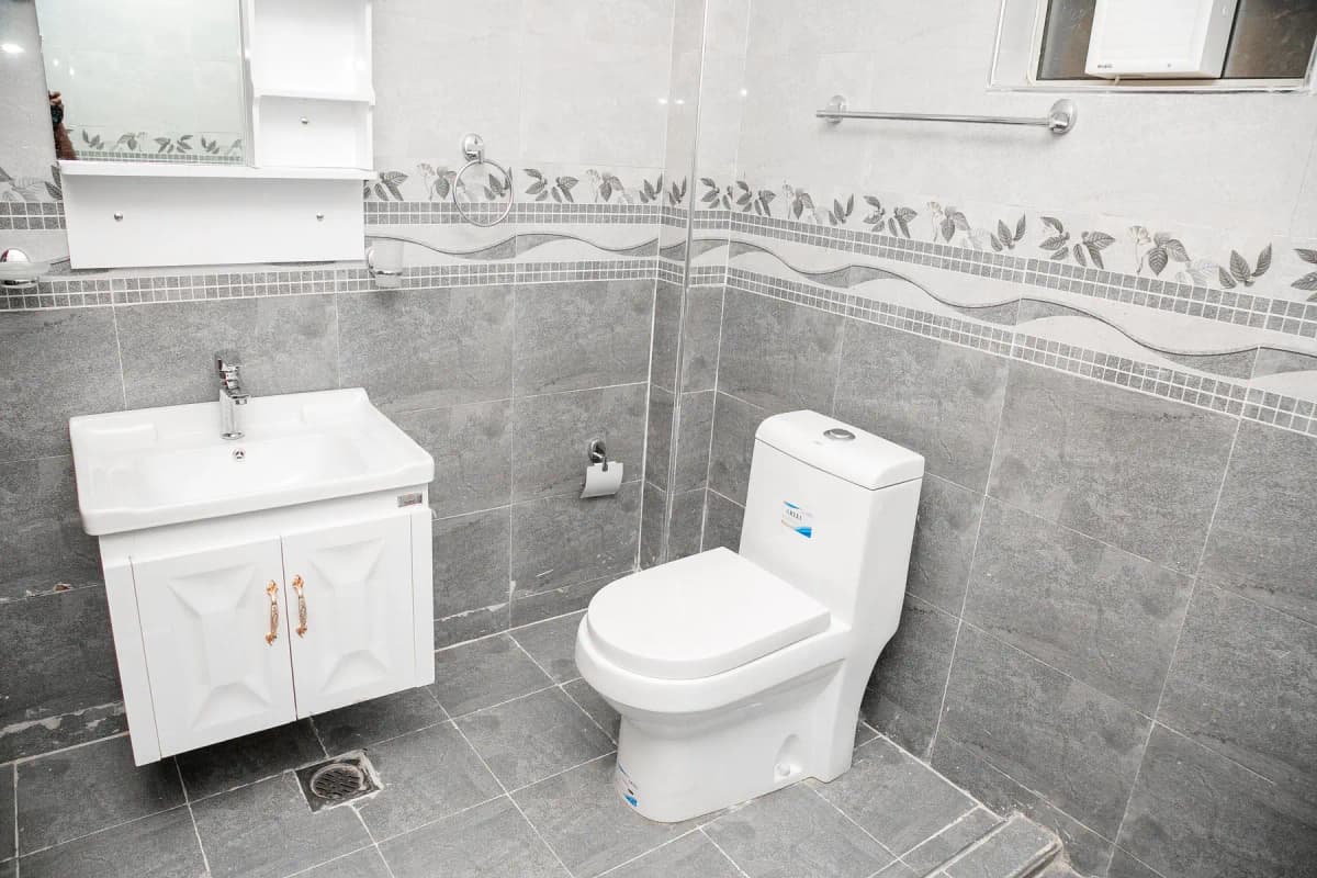 Modern bathroom with gray tiled walls and white fixtures