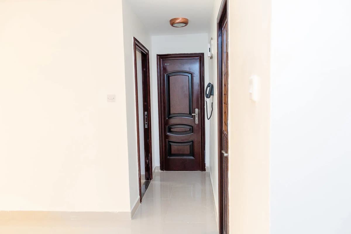 Clean hallway with wooden door and polished floor
