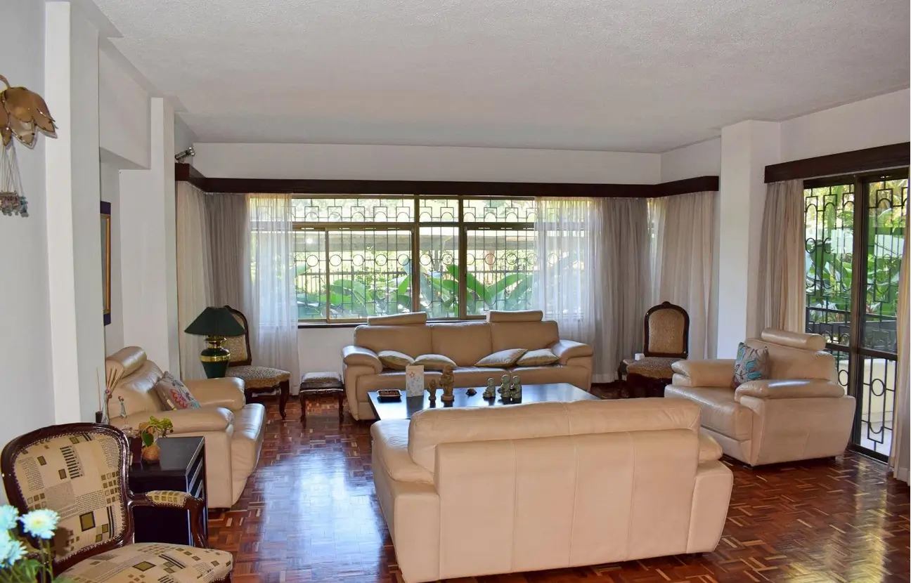 Spacious living room with multiple seating areas and garden views